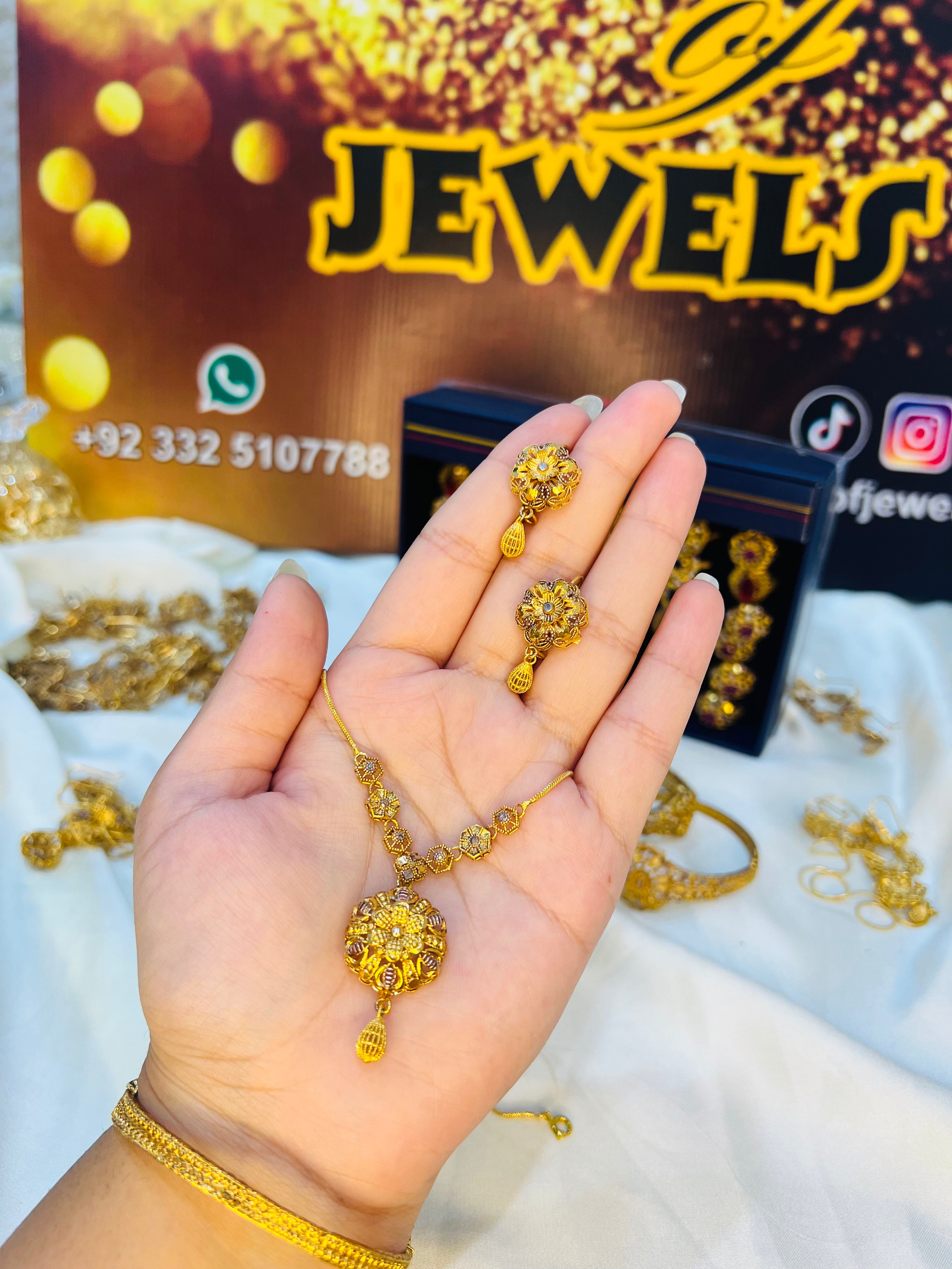 Gold jewelry set displayed on a hand with 'Jewels' branding in the background